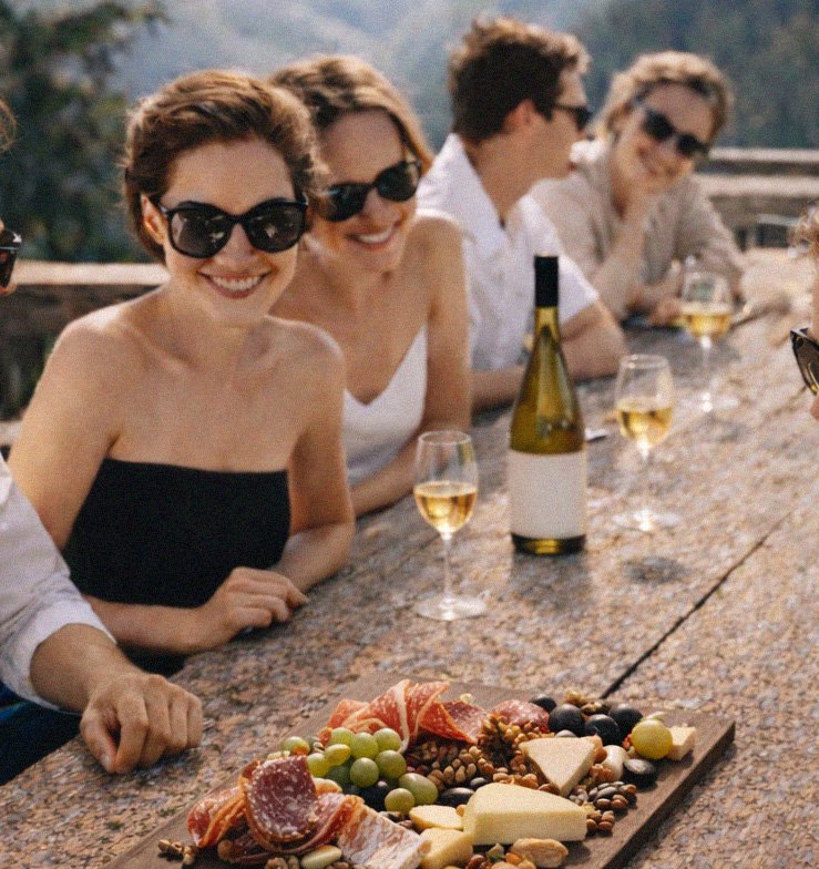 Une tablée en terrasse face aux montagnes, verres de vin blanc